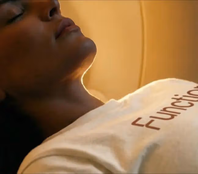 Woman in a Function shirt lying calmly with eyes closed during an MRI scan.