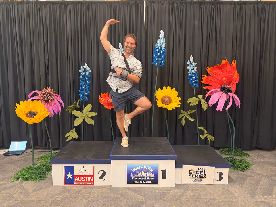 Mason balancing on a winners podium with his arm in a sling after a shoulder injury