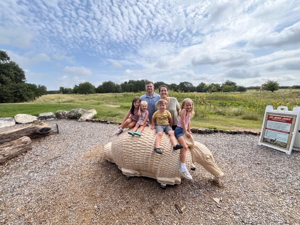 Tanner and his family posing outdoors at Mother Neff State Park.