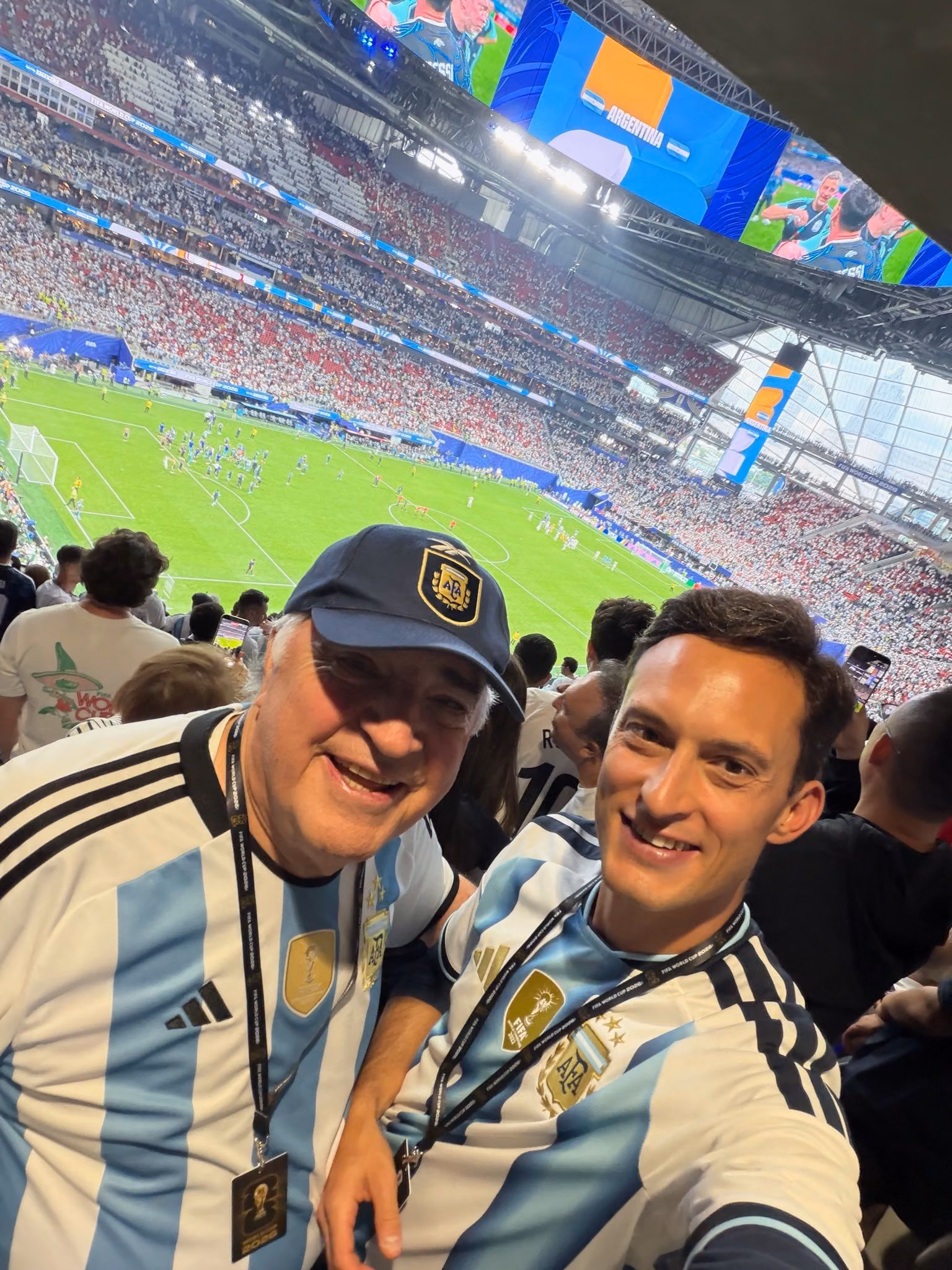 JP and his father smiling at a soccer stadium in Argentina jerseys