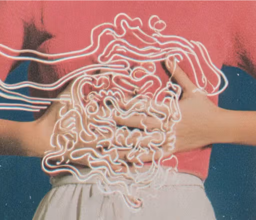 Hands holding an abdomen overlaid with a glowing line drawing of the digestive tract on a pink background.