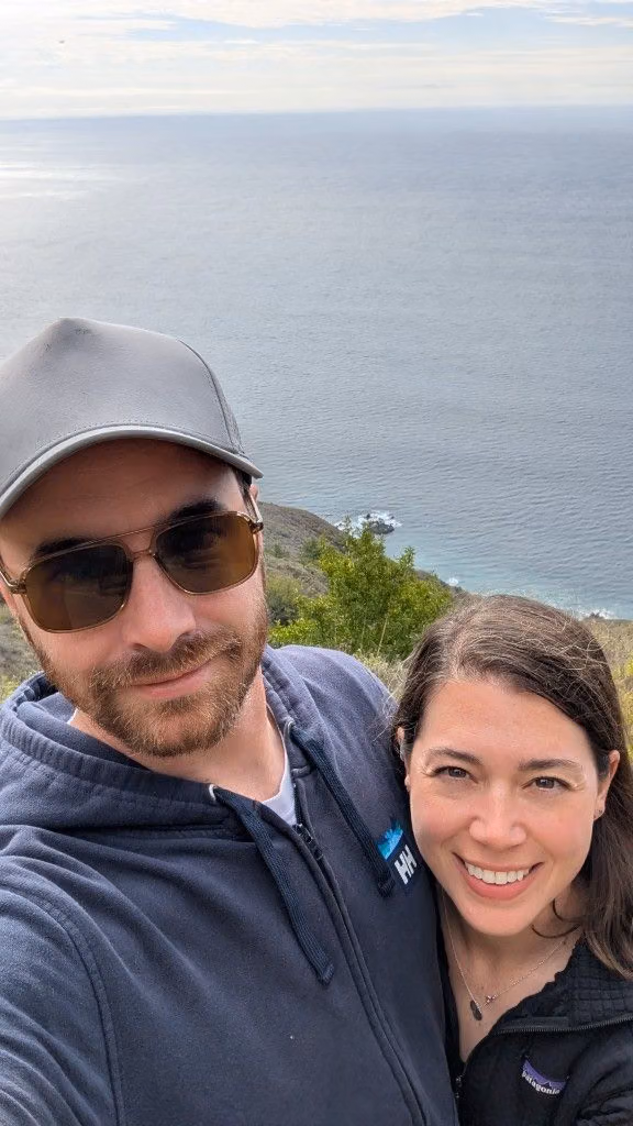 Mitchell and his wife taking a selfie on a coastal overlook.