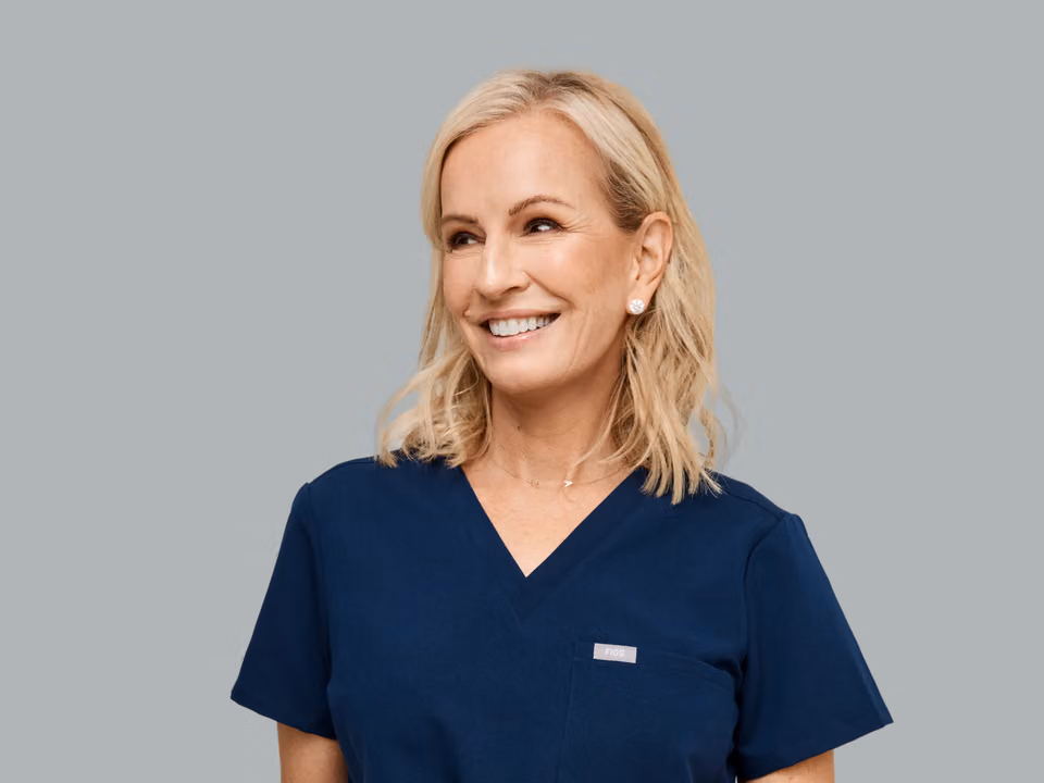 Portrait of Dr. Jen Ashton in navy scrubs, smiling.