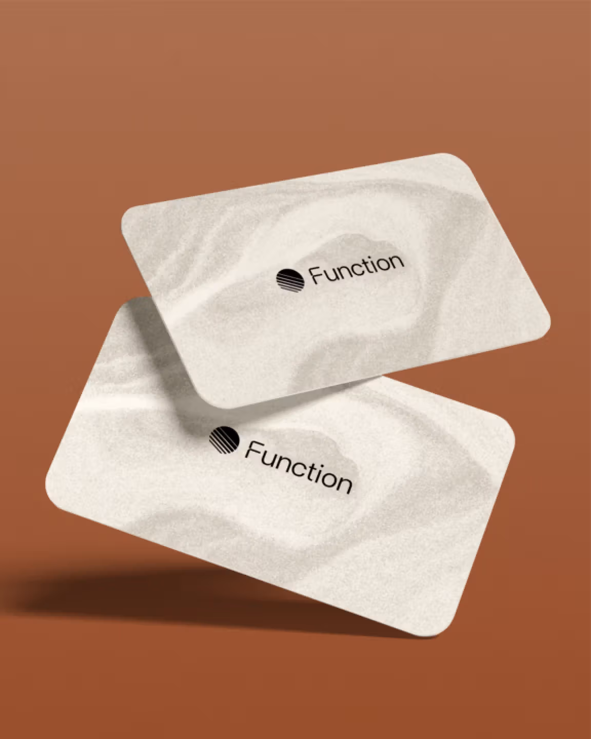 Two floating Function Health branded cards with a sand-textured design on a warm terracotta background